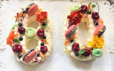 デコレーションされた数字「80」のナンバーケーキ 【ナンバーケーキ】赤いサクランボ、マカロン、鮮やかなオレンジ色の花でデコレーションされた数字「80」のデコレーションケーキ。